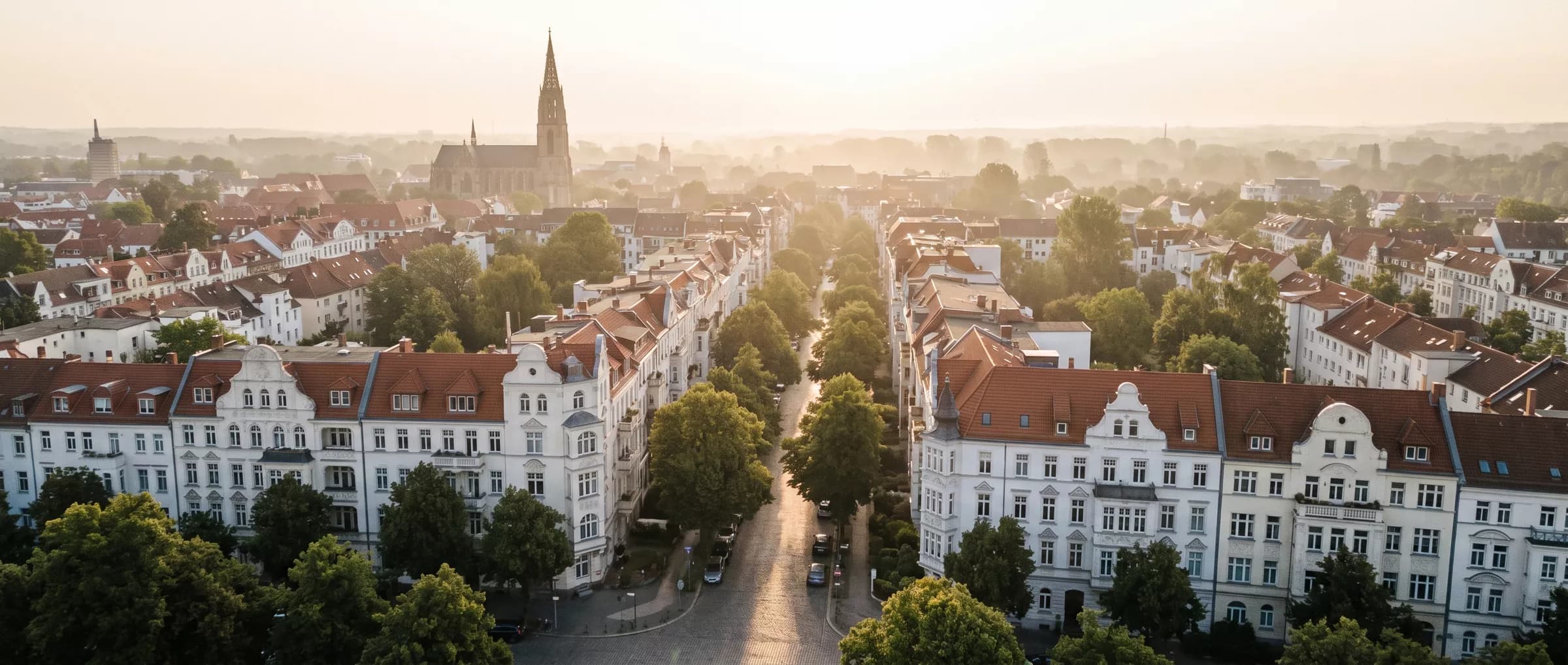 Luftbild einer deutschen Altbau-Stadt im Abendlicht (KI-Bild)